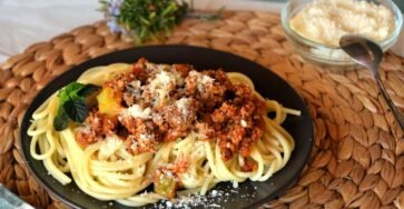 Spaghetti Bolognese with rich meat sauce, tomato base, and grated Parmesan cheese