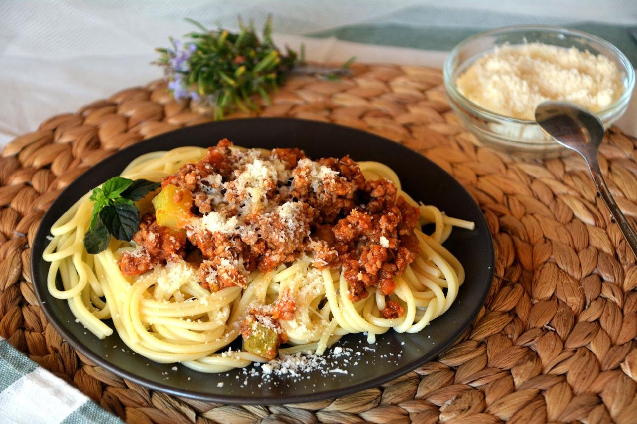 Spaghetti Bolognese with rich meat sauce, tomato base, and grated Parmesan cheese