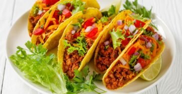 Classic beef tacos with ground beef, lettuce, cheese, and salsa in taco shells