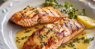 Lemon garlic butter salmon fillet served with fresh lemon and herbs